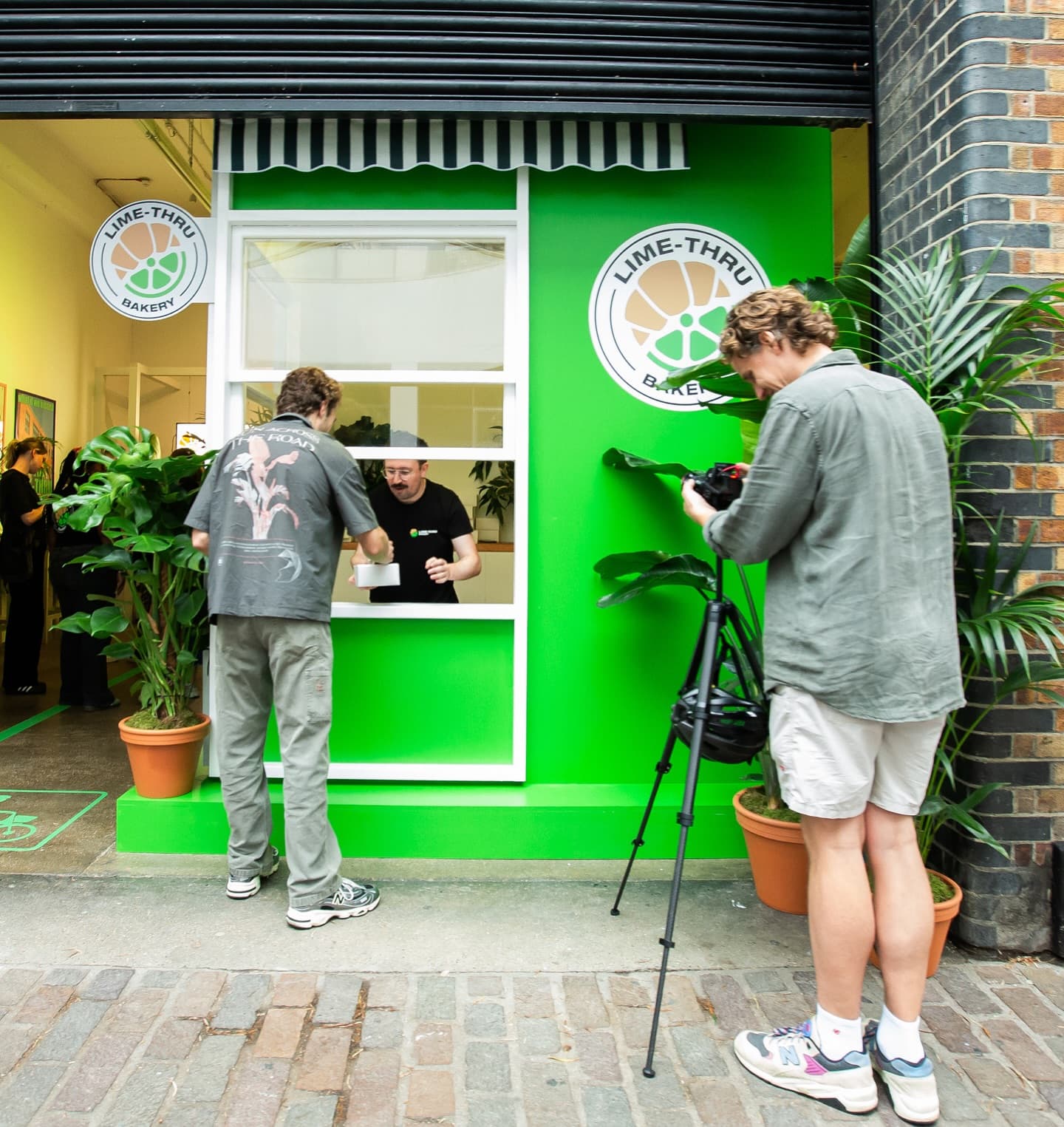 The Lime-Thru Bakery exterior with its green facade, striped awning, and street-facing service window in Shoreditch