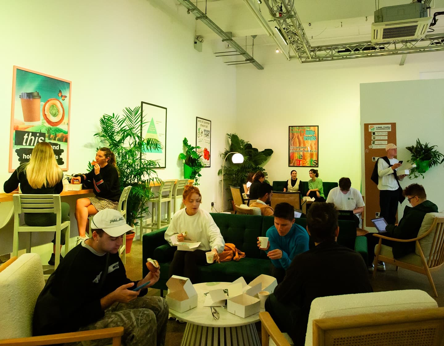 The Lime-Thru Bakery lounge area filled with customers relaxing on sofas with coffee and cronuts